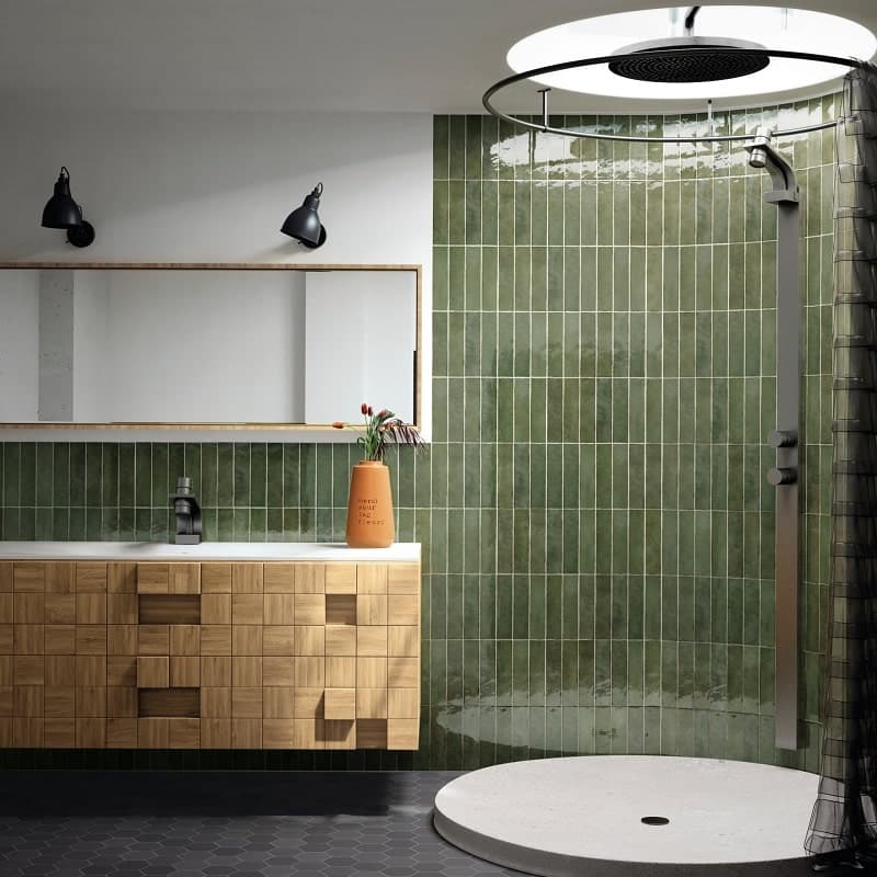 Zellige vert dans salle de bain moderne avec meuble en bois clair et douche ouverte sur fond carrelage noir
