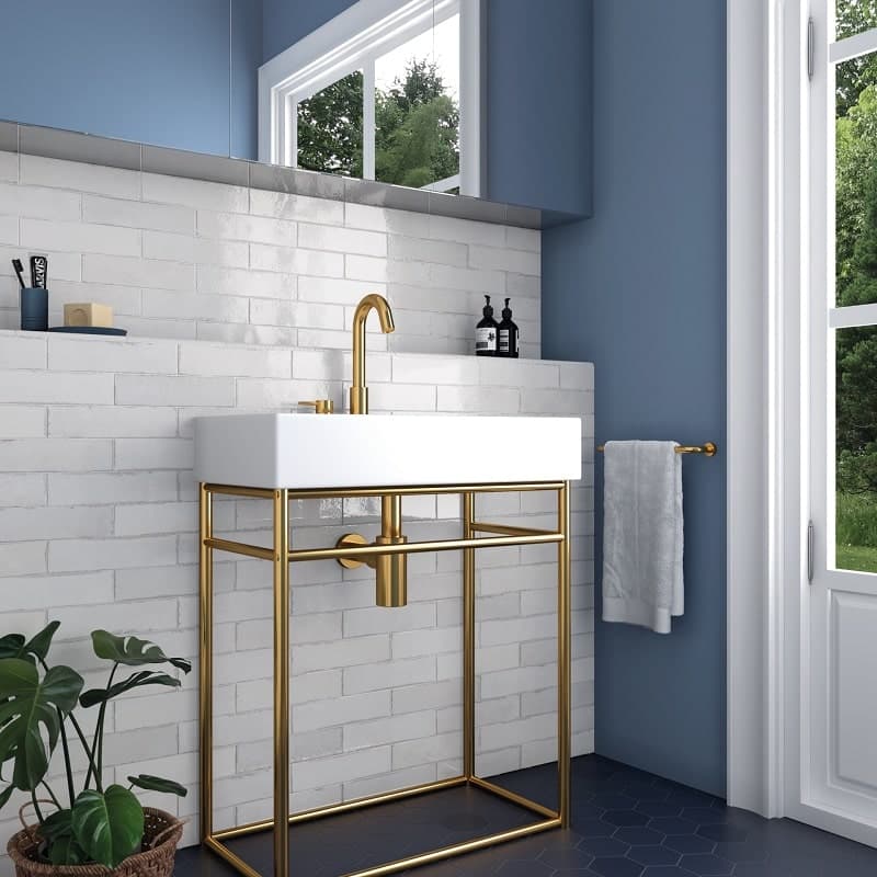 Zellige blanc brillant dans une salle de bains murs blancs, mobilier doré, sol bleu foncé hexagonal, lumineux, élégant