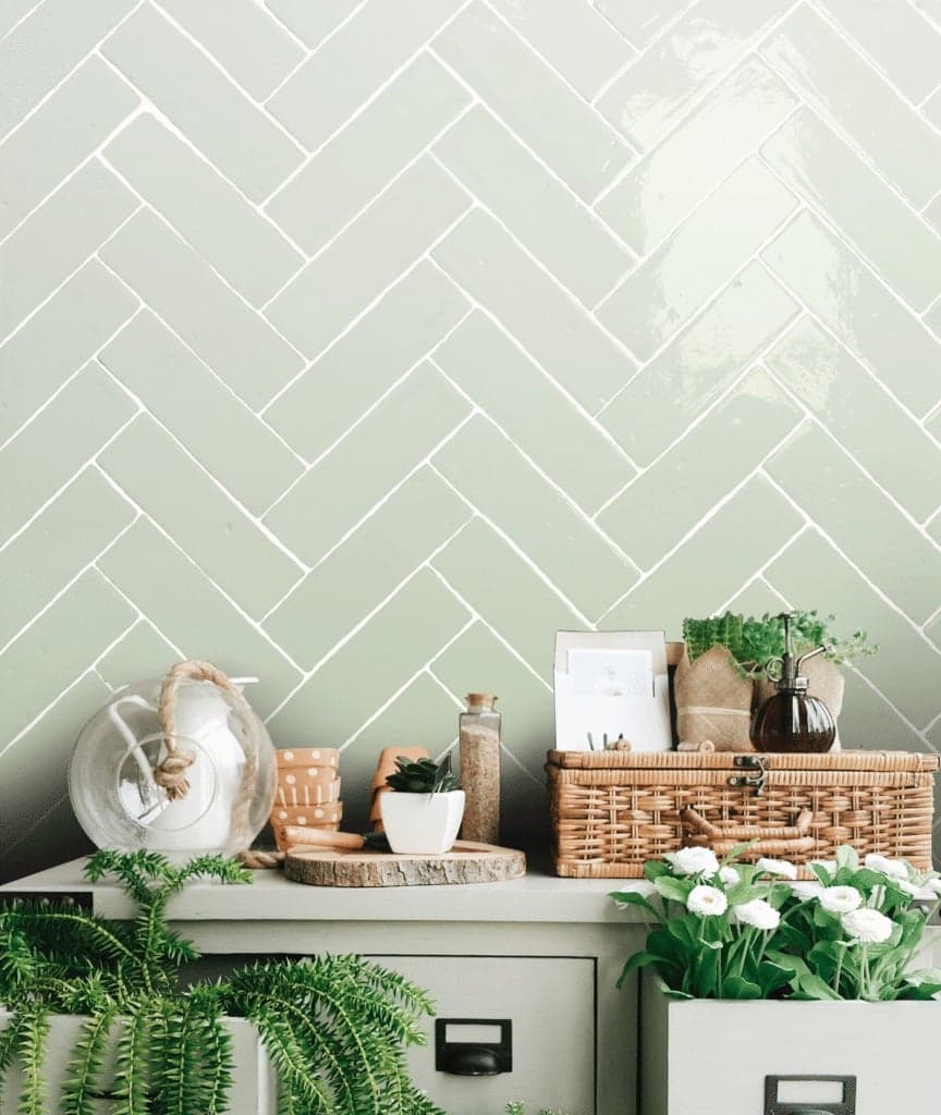 Relief vert clair carrelage 6X20 dans une cuisine tons de bois naturel plantes vertes et décoration en osier sur le comptoir