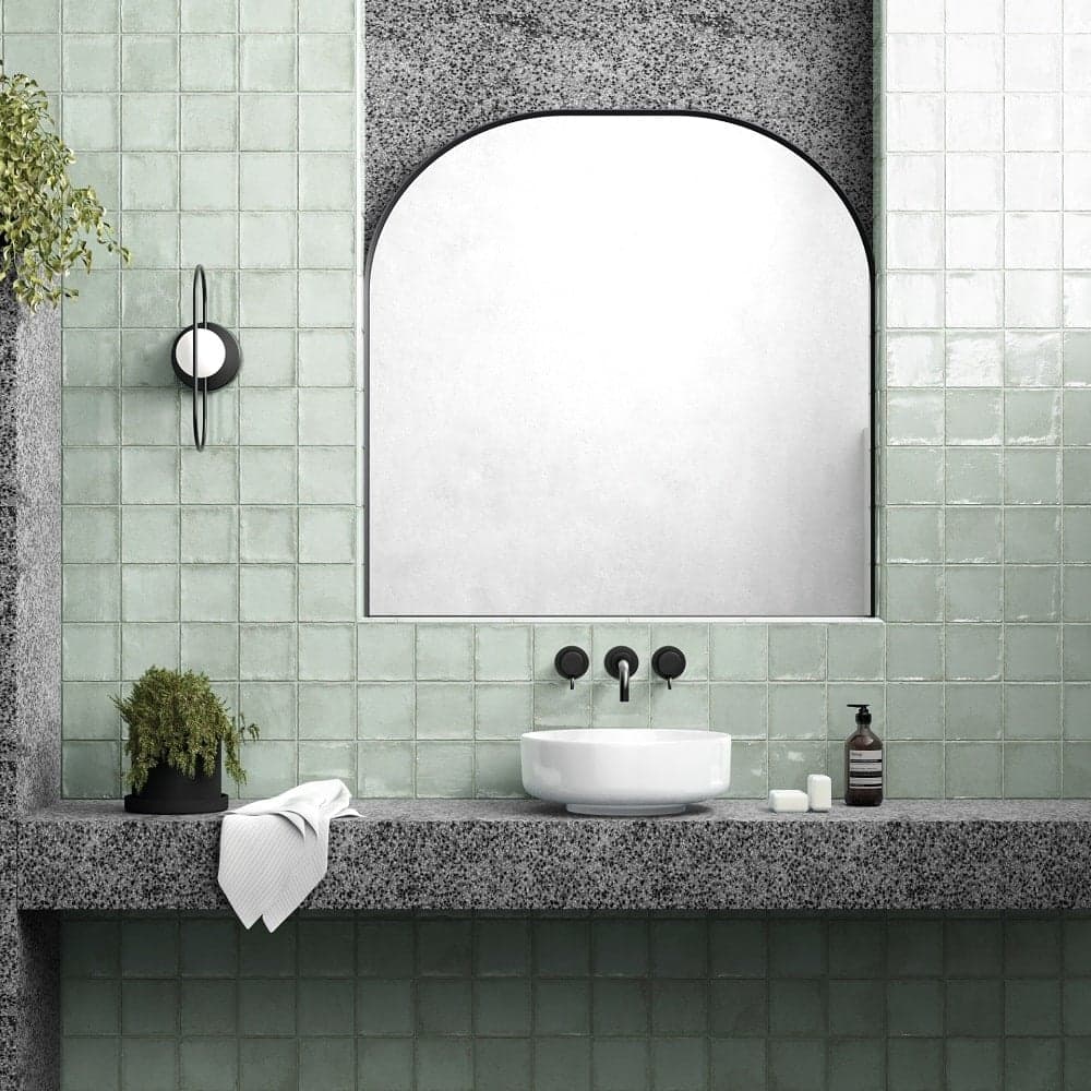 Carrelage Zellige vert uni 10x10 cm sur mur de salle de bain tons de gris avec vasque blanche et miroir arrondi