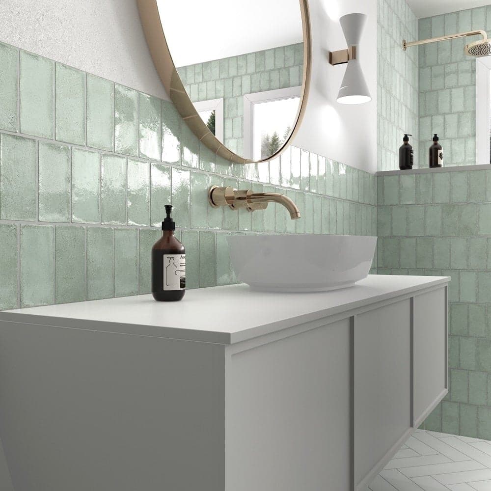 Zellige vert nuances deau sur carrelage 10x10 cm dans une salle de bain blanc vasque et robinetterie dorées
