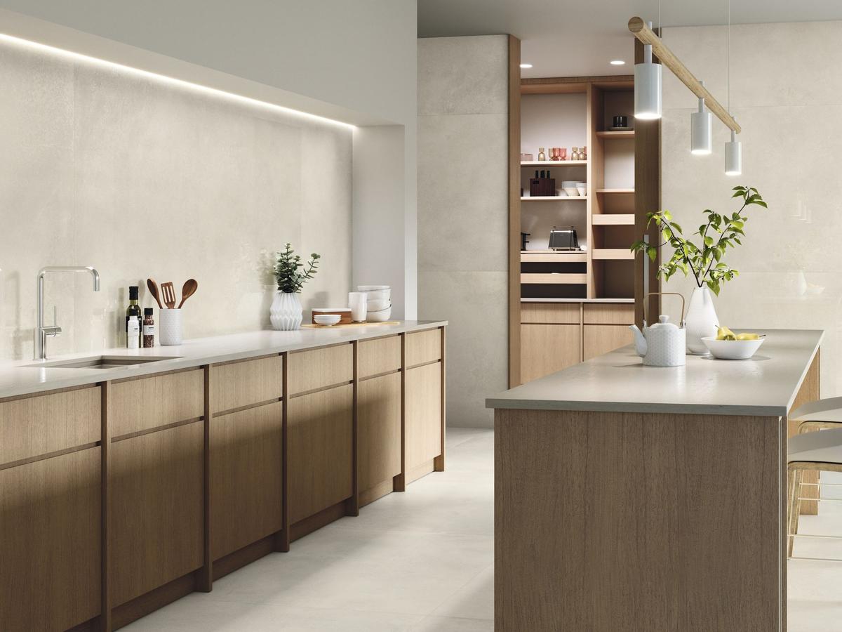 Carrelage béton beige lisse 60x60 cm dans une cuisine moderne avec meubles bois clair et plans blancs