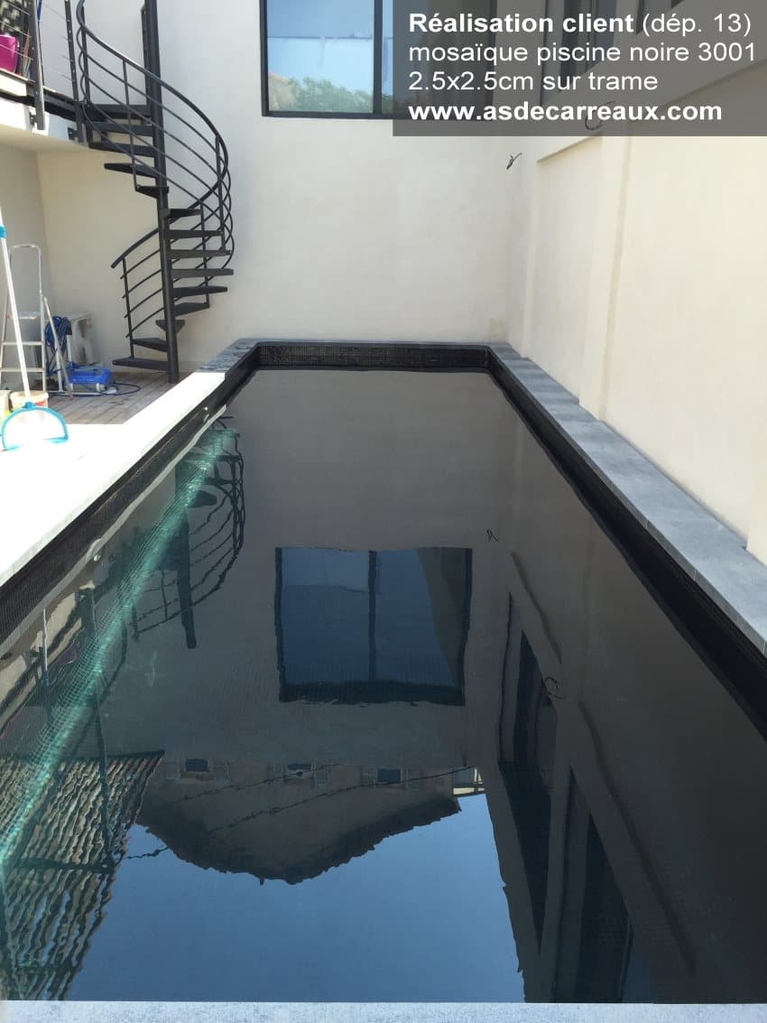 Carrelage uni noir dans une piscine extérieure, entourée de murs créme, avec escalier en colimaçon noir