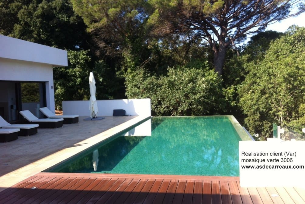 Carrelage uni vert sans motifs sur terrasse avec piscine, bois et mobilier blanc, ambiance moderne et arborée