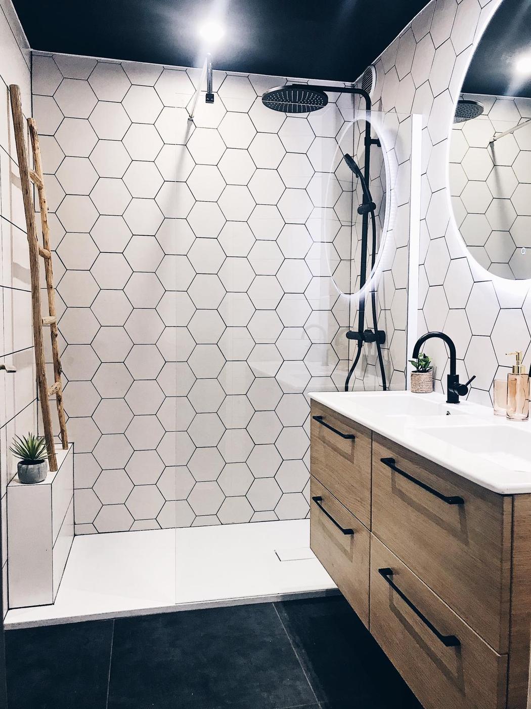 Carrelage Pierre Blanc hexagonal 17.5x20 cm dans une salle de bain moderne avec meuble en bois et détails noirs