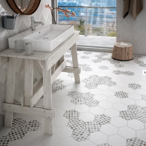 Carrelage aspect pierre blanc avec motifs géométriques gris 17.5x20 cm dans une salle de bain éclairée tons clairs avec meuble lavabo bois et accessoires whiteColorReset