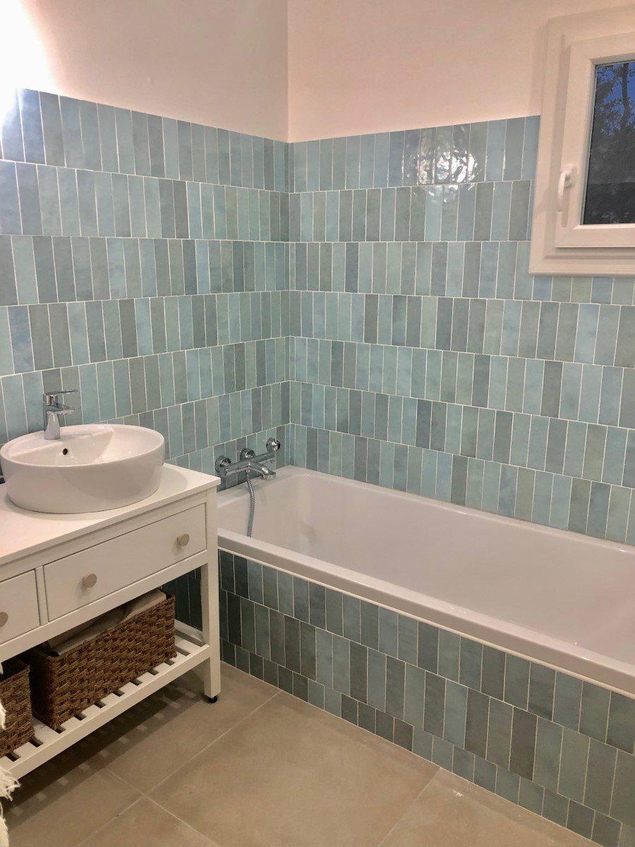 Zellige carrelage bleu pastel 6,5X20 dans une salle de bain tons neutres avec baignoire blanche et meuble blanc