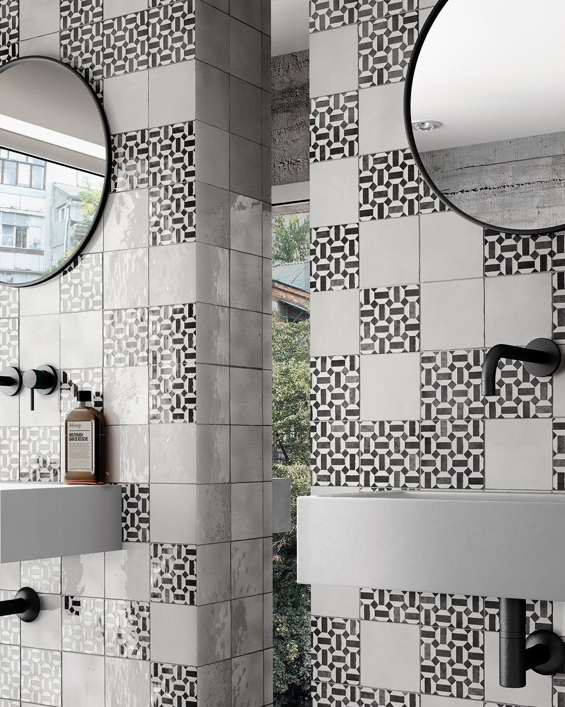 Zellige blanc avec motifs géométriques 15x15 cm dans salle de bain moderne tons gris lavabo noir miroir rond
