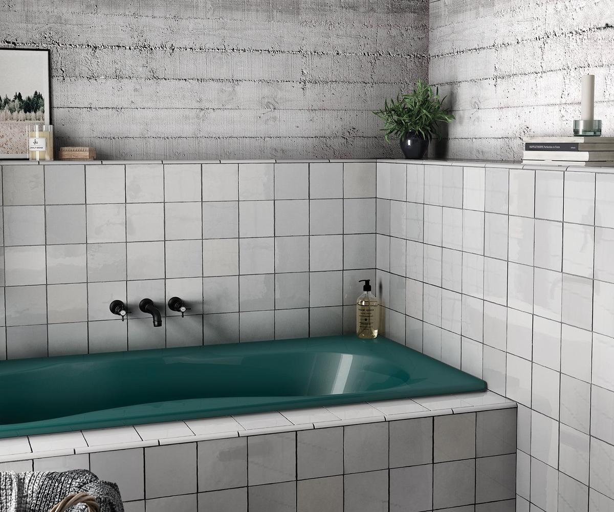 Zellige blanc mat 15x15 cm dans une salle de bain tons gris avec baignoire verte et accessoires décoratifs