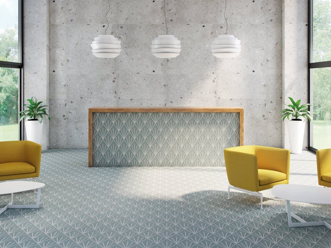 Carreau de ciment bleu clair motifs géométriques 19.9x23 cm dans un salon moderne avec murs béton et fauteuils jaunes