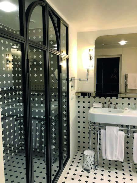 Carrelage blanc uni dans une salle de bain épurée avec des touches de noir sur meubles et accessoires