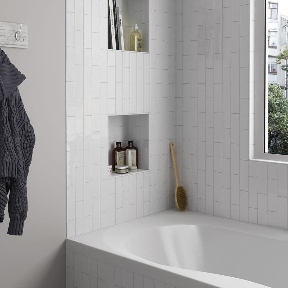 Carrelage uni blanc dans une salle de bain moderne avec des accessoires en bois et accents gris sur textile et produits