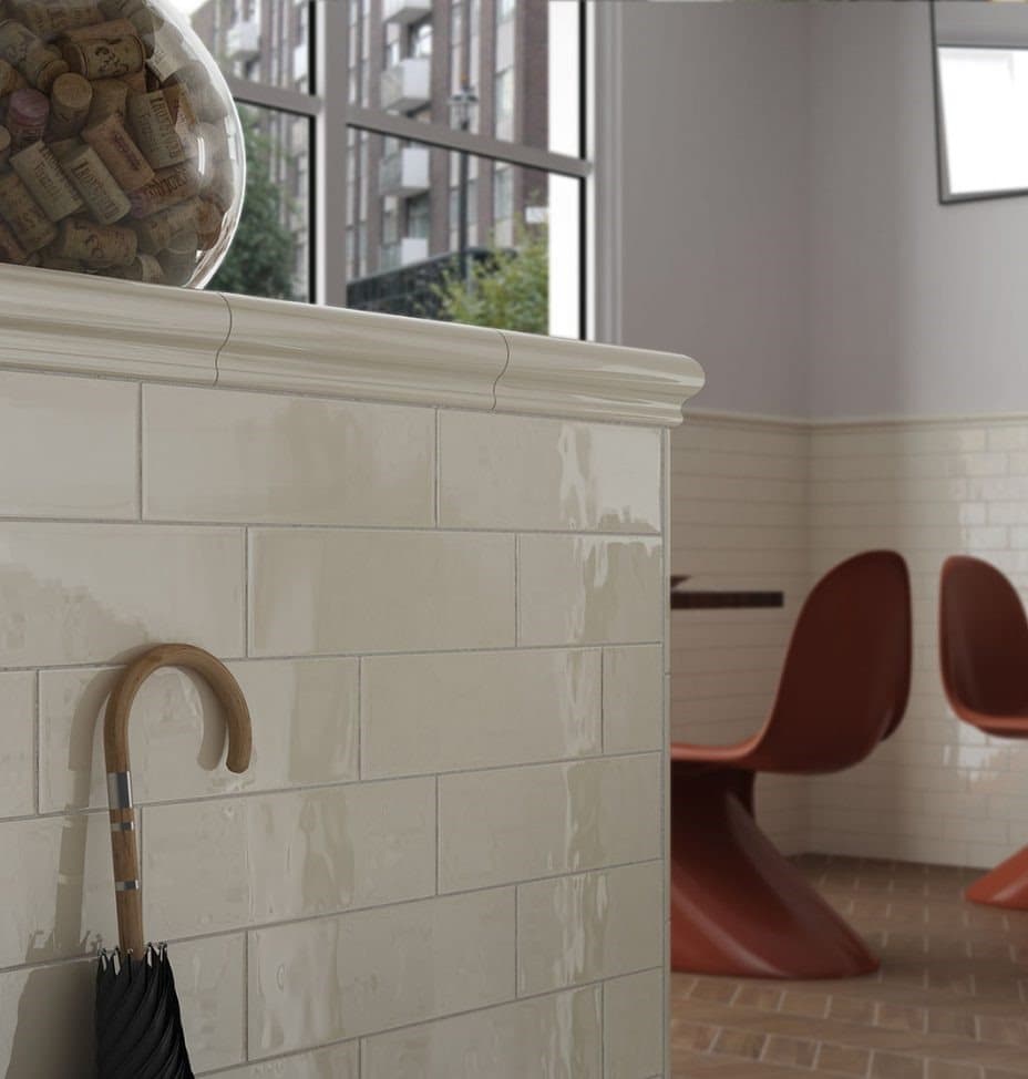Carrelage uni beige sur un mur intérieur avec chaises rouges et sol en terre cuite