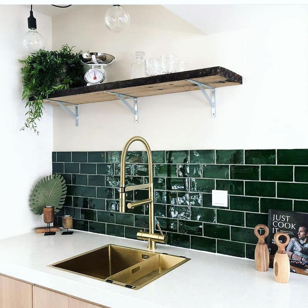 Carrelage uni vert émeraude 7,5x15 cm dans une cuisine épurée blanche avec plans en bois et robinetterie dorée