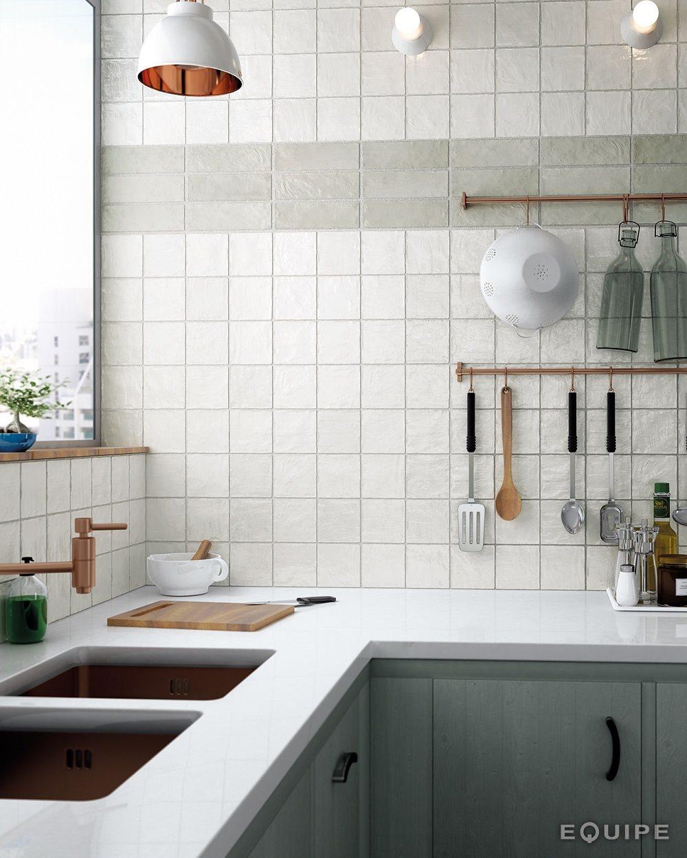 Zellige blanc brillant 10x10 cm dans une cuisine aux meubles gris et plans de travail blancs accueillant accessoires de cuisine et évier