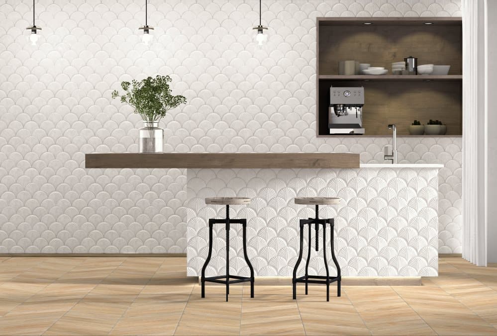 Carrelage uni blanc avec motifs subtils 30x30 cm dans une cuisine moderne tons bois et noir, tabourets hauts, suspensions, plante