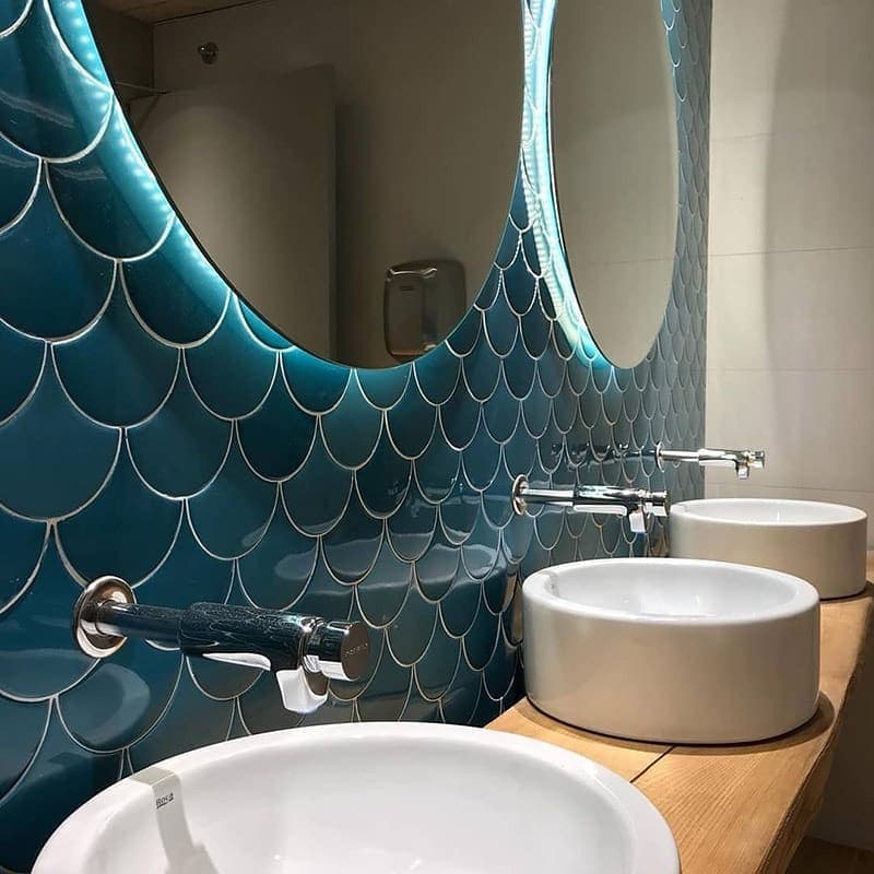 Carrelage uni écaille bleu turquoise sans motifs 12,7X6,2 sur un mur de salle de bain blanche avec lavabos ronds et miroir ovale
