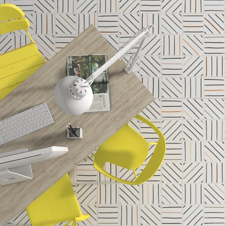 Carrelage effet tissu multicouleur avec motifs linéaires 20x20 cm sur un bureau jaune et blanc avec accessoires modernes