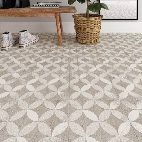 Carreau de ciment gris à motifs géométriques 20x20 cm dans un salon sur fond blanc avec un panier et une plante