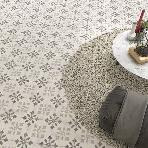 Carreau de ciment gris à motifs floraux 20x20 cm sur un salon aux tons neutres avec canapé, tapis rond et table basse