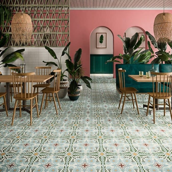Carreaux de ciment verts avec motifs floraux taille 50x100 cm dans une salle à manger aux murs roses et meubles en bois