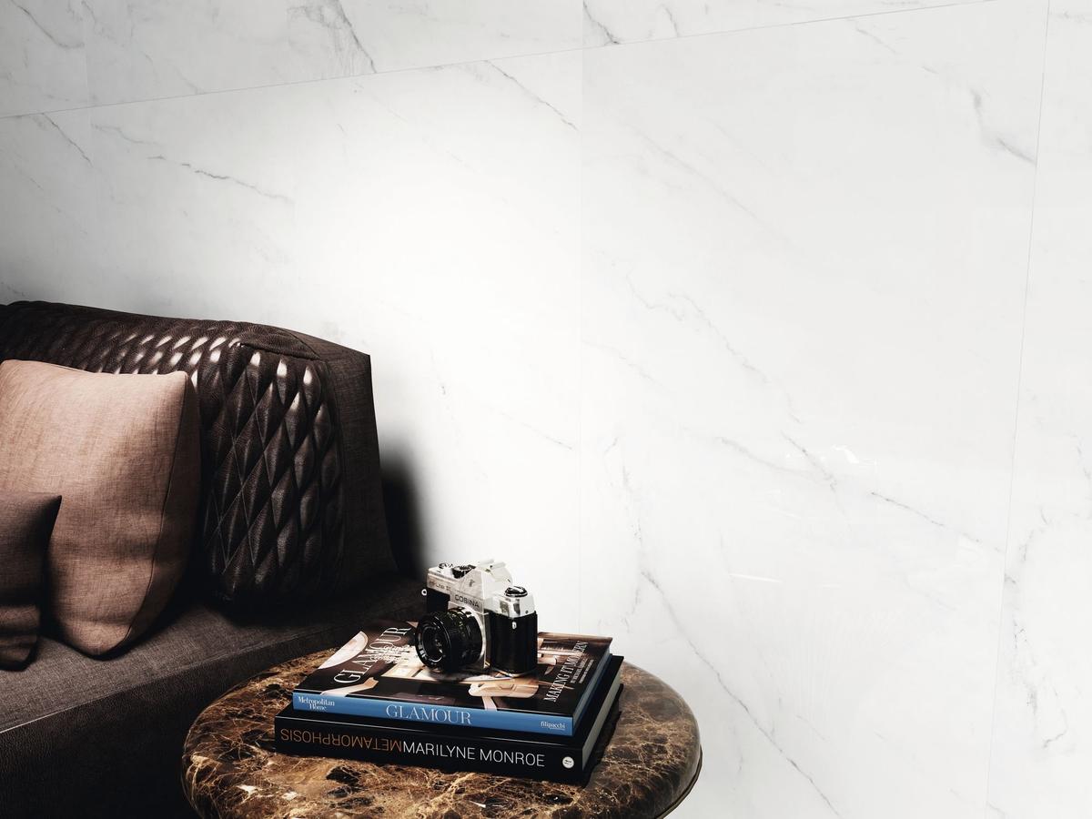 Carrelage marbre blanc veiné 60x120 cm dans un salon moderne avec canapé marron et table basse en marbre