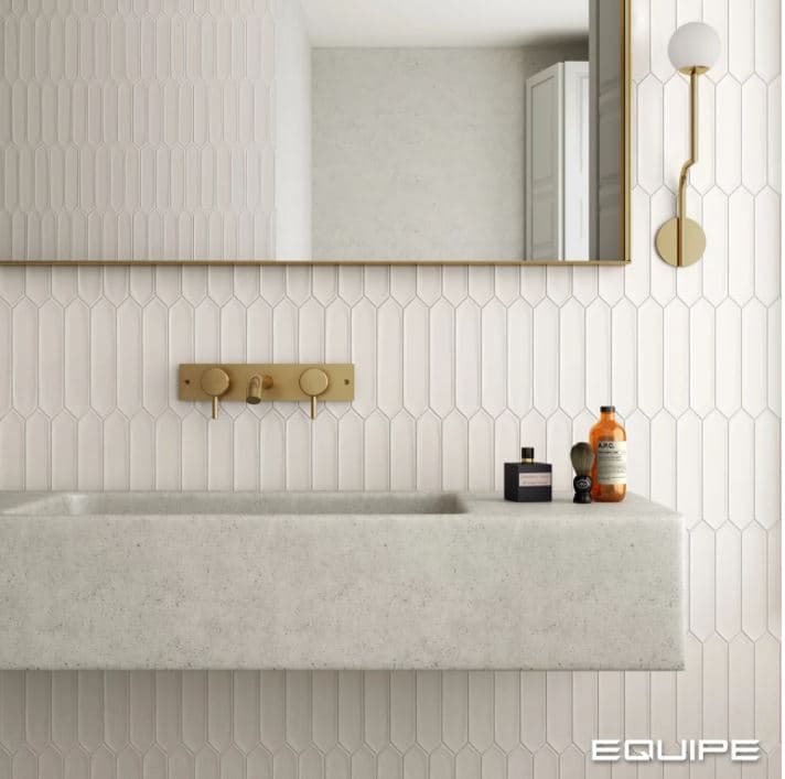 Carrelage uni blanc 5X25 dans une salle de bain moderne tons clairs robinetterie dorée éclairage mural élégant