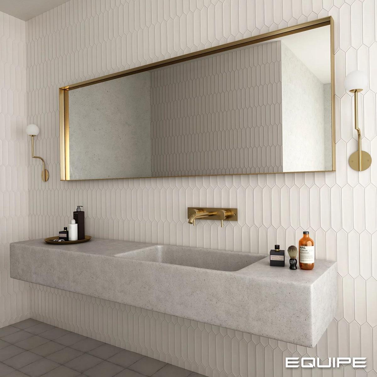 Carrelage uni blanc 5X25 dans une salle de bain dominante blanche avec vasque en pierre et accessoires dorés sur le mur