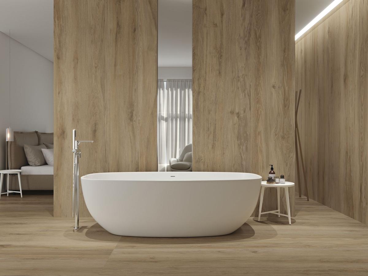 Carrelage effet bois beige lisse 20x120 cm dans une salle de bain tons clairs avec baignoire blanche, mobilier minimaliste, éclairage doux