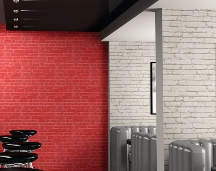 Carrelage blanc en relief sur mur dintérieur contrastant avec section rouge, dans cuisine moderne avec mobilier noir et gris