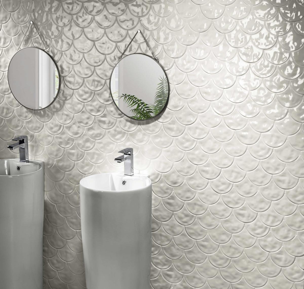 Carrelage uni blanc avec relief ondulé 30x30 cm dans une salle de bain moderne murs gris clair avec deux lavabos ronds et miroirs circulaires