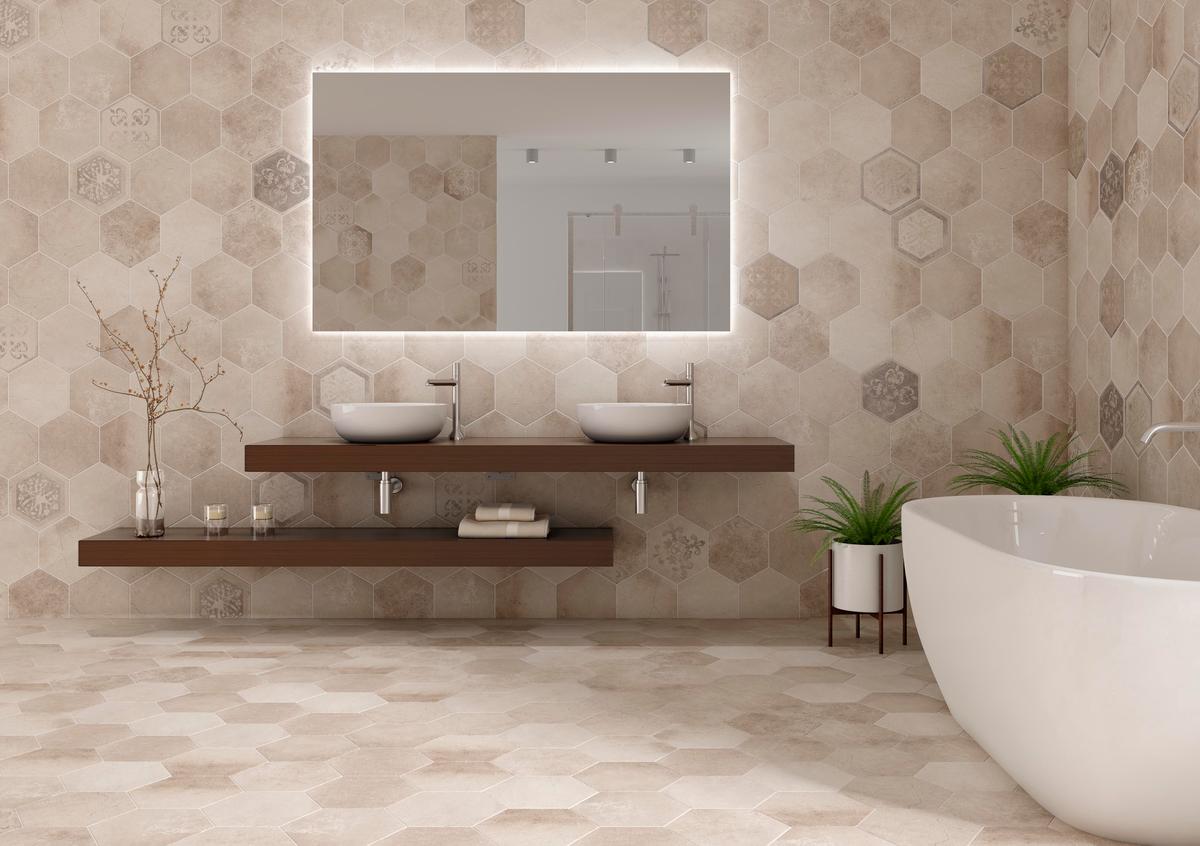 Carrelage aspect pierre beige avec motifs hexagonaux sur une salle de bain épurée blanc cassé avec baignoire moderne et vasque sur meuble en bois