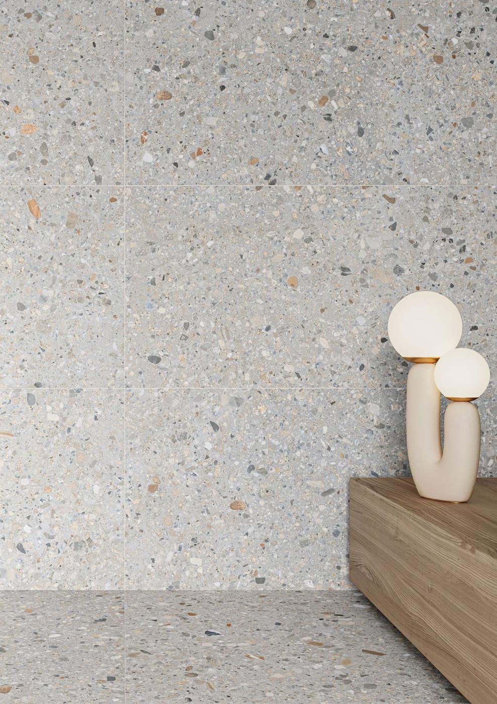 Carrelage Terrazzo blanc avec nuances de gris et touches de marron 60x60 cm sur sol et mur dans espace moderne avec lampe décorative beige