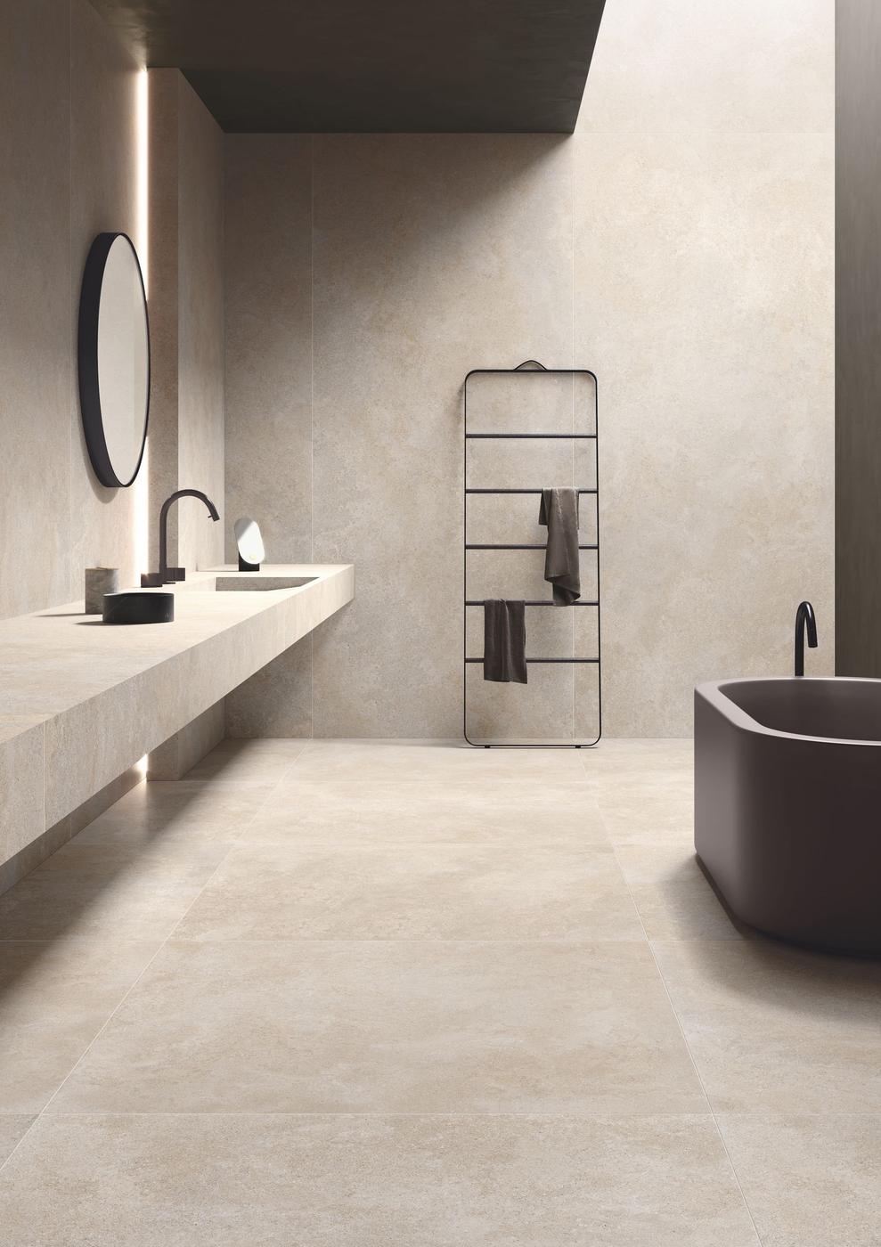 Carrelage effet pierre beige nuances douces 60x60 cm dans salle de bain moderne tons gris baignoire noire étagère métal