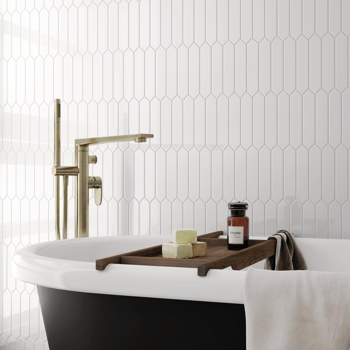 Carrelage uni blanc dans une salle de bain épurée avec baignoire noire et blanche, accents dorés, serviettes et accessoires relaxants