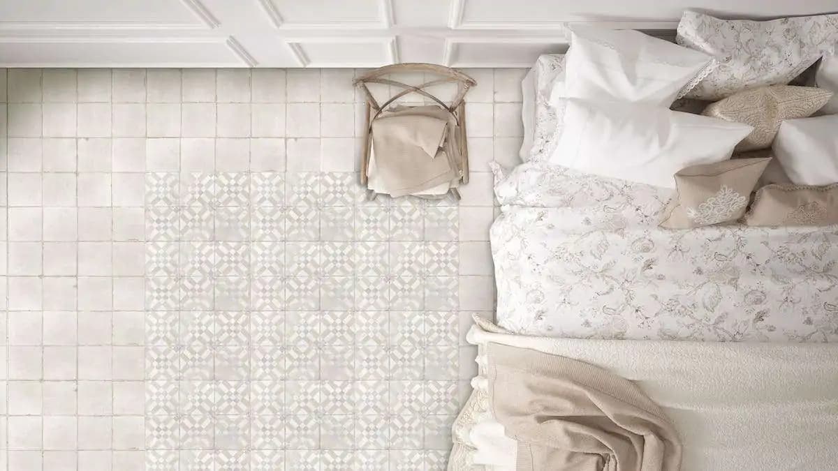 Carreau de ciment beige motifs géométriques 15x15 cm dans une chambre tons neutres linge de lit et coussins