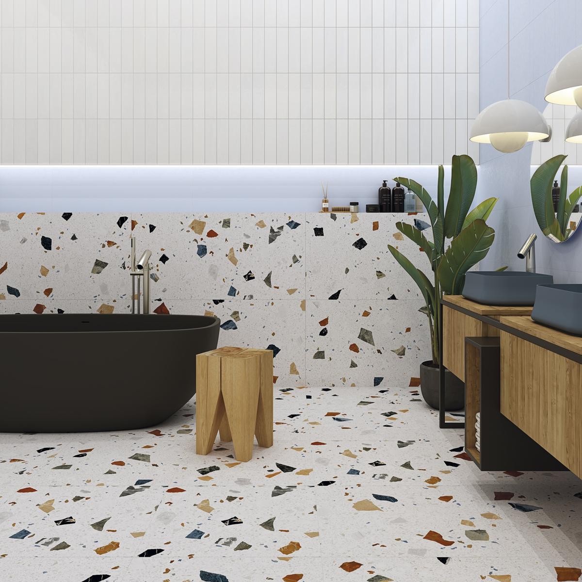 Carrelage Terrazzo blanc avec éclats colorés 60x60 cm dans salle de bain moderne aux murs blancs, meubles bois, baignoire noire