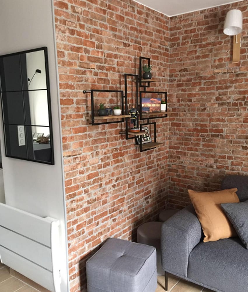 Carrelage relief terracotta dans un salon moderne avec canapé gris, étagères murales et miroir