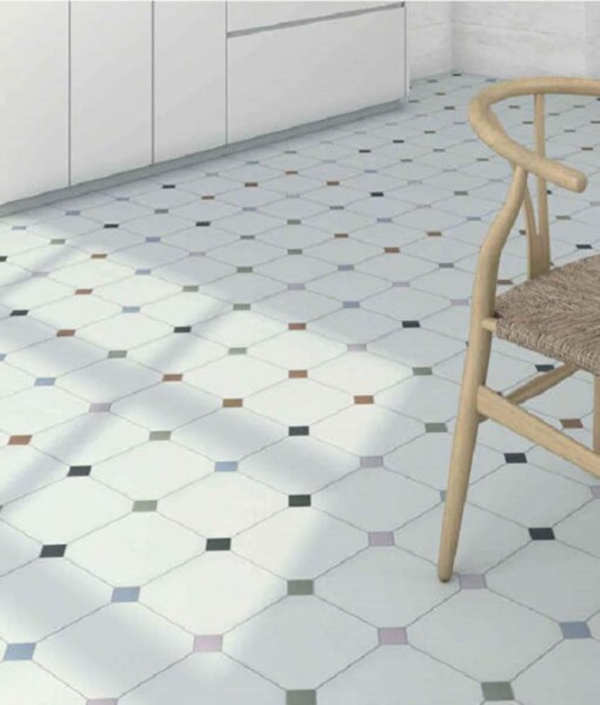 Carrelage uni multicouleur avec touches de bleu et rose 20x20 cm dans une cuisine blanche avec mobilier en bois et chaise tressé