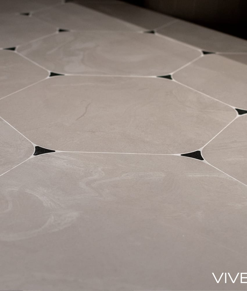 Carrelage aspect béton couleur beige avec motifs géométriques noirs en incrustation