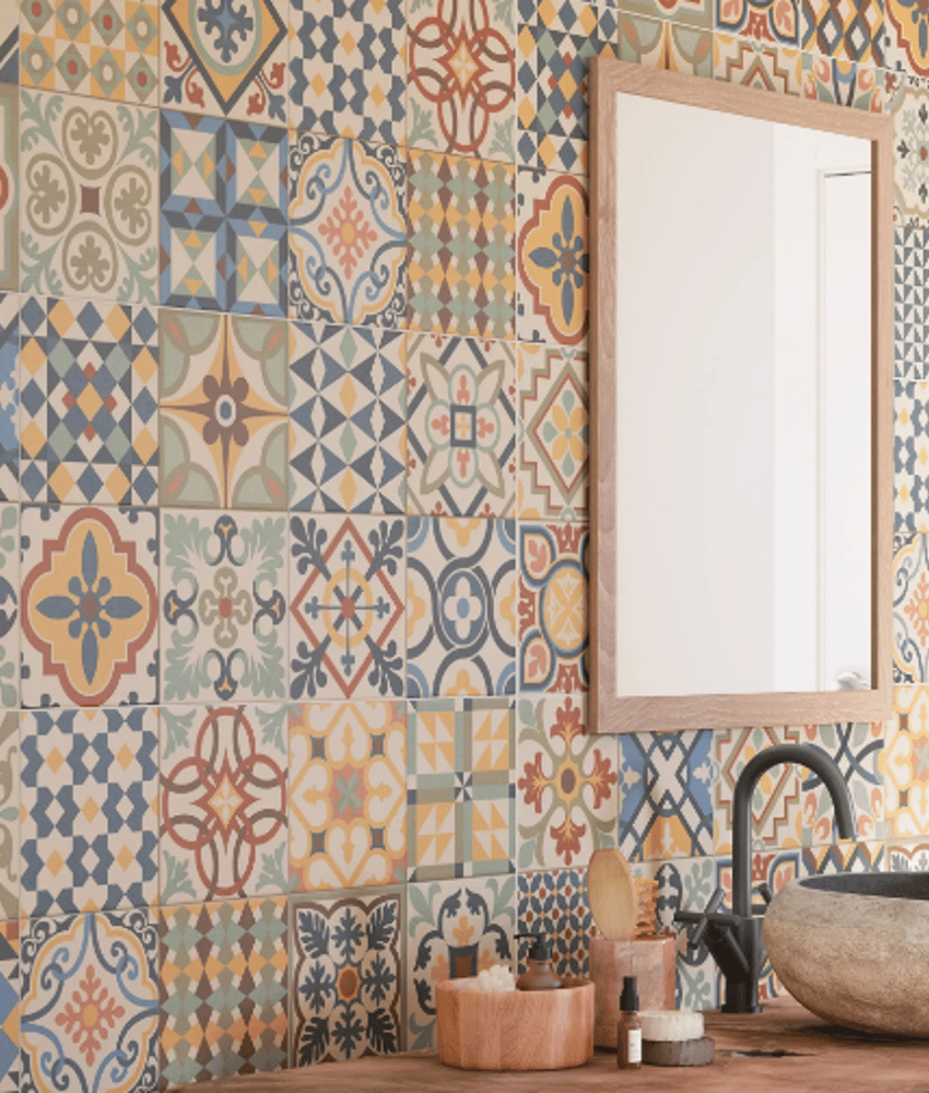 Carreau de ciment multicouleur motifs géométriques et floraux 30x30 cm dans une salle de bains tons chauds avec vasque en pierre