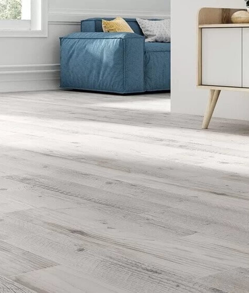 Carrelage aspect bois marron clair veiné en grès cérame 15x90 cm dans un salon épuré avec mobilier blanc et touches de bleu