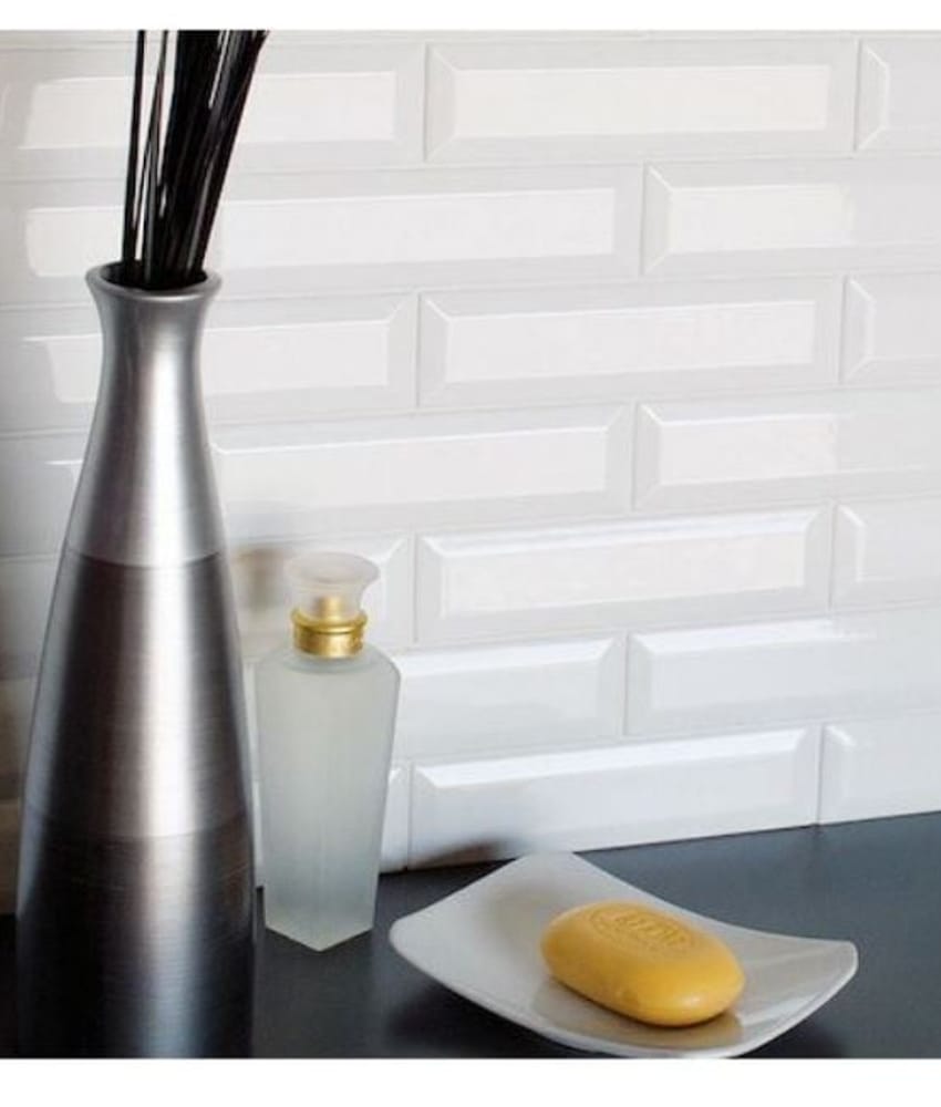 Carrelage uni blanc 10x30 cm sur un mur avec décoration vase noir et savon jaune sur plateau blanc