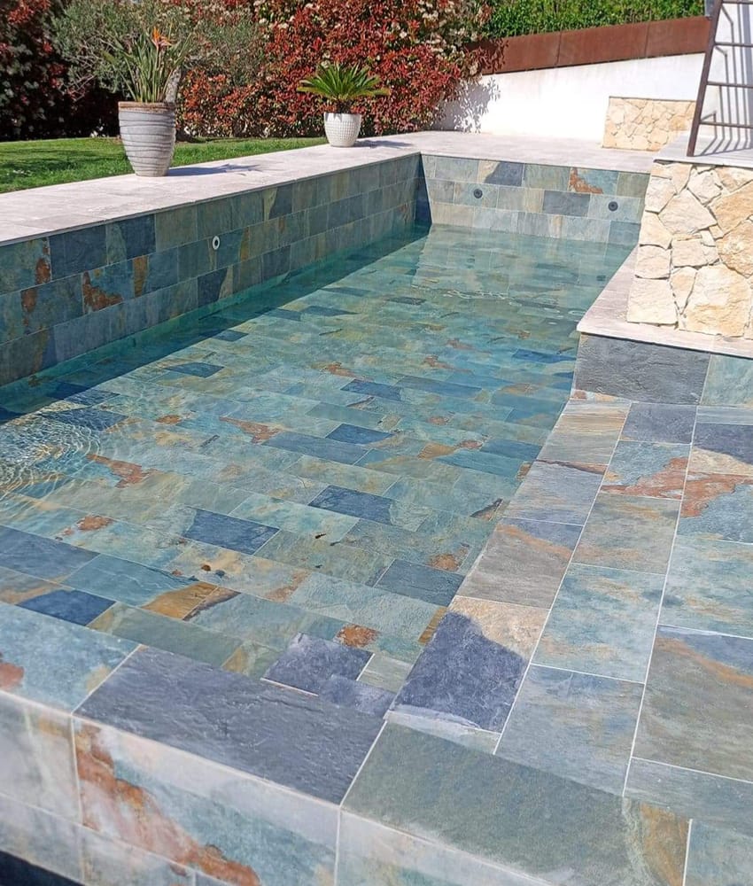 Carrelage pierre multicouleur 30x60 cm dans une piscine extérieure avec des tons bleus et verdâtres sur les murs et sol