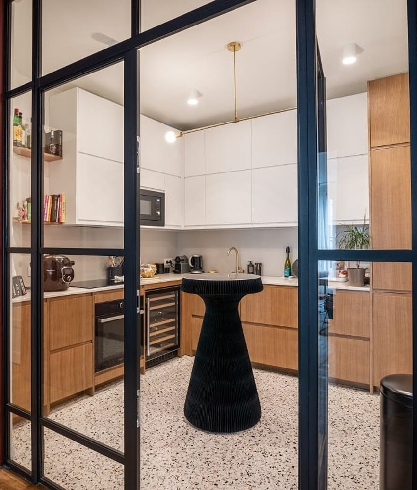 Carrelage Terrazzo blanc avec nuances de noir et gris 20x20 cm dans une cuisine moderne tons bois clair et éléments noirs