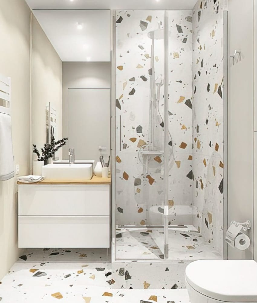 Carrelage Terrazzo blanc avec éclats colorés 60x60 cm dans une salle de bain beige avec mobilier blanc et miroir