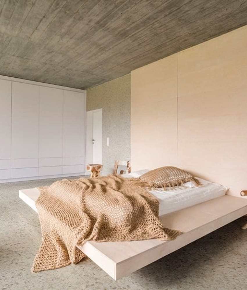 Carrelage Terrazzo beige avec nuances gris clair 60x60 cm dans une chambre minimaliste aux murs blancs et plafond en béton, écla