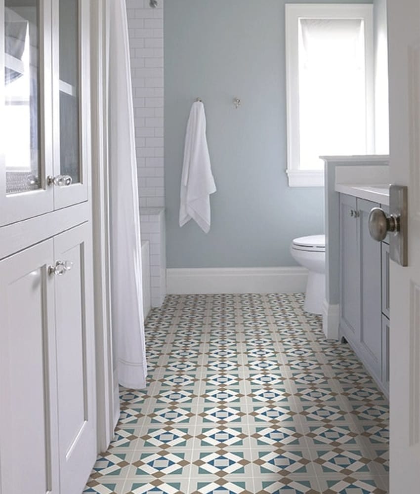 Carreau de ciment vert avec motifs géométriques bleu et beige 20x20 cm dans une salle de bain blanche avec des éléments en bois 