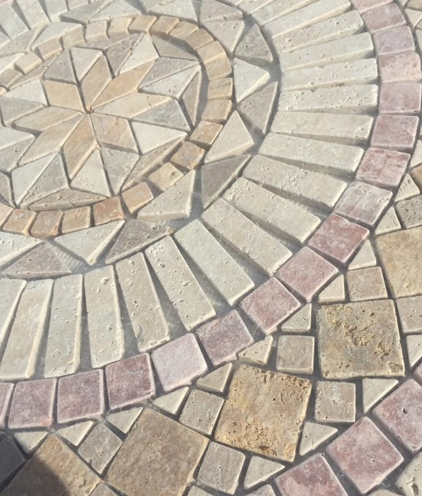 Carrelage pierre beige avec motif central composé et bordures roses, mise en valeur en extérieur