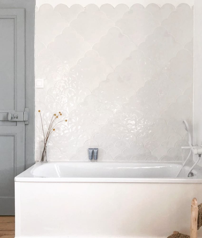 Carrelage blanc uni motifs subtils en relief 30x30 cm dans une salle de bain nuances de gris accessoires bois et blancs